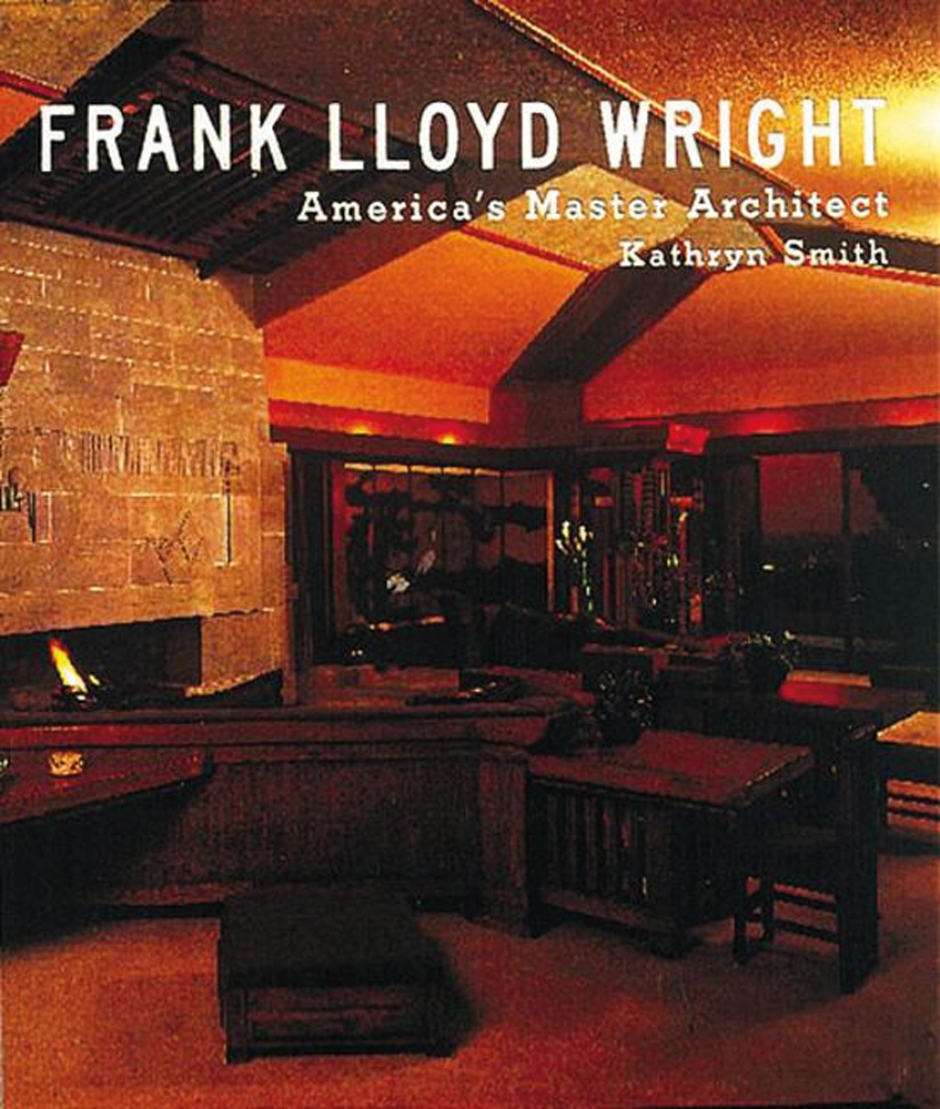 Dark interior with dark brown furniture, illuminated with orange light, FRANK LLOYD WRIGHT America's Master Architect, in white font above.