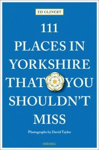 Yorkshire rose badge near center of blue cover of '111 Places in Yorkshire That You Shouldn't Miss', by Emons Verlag.