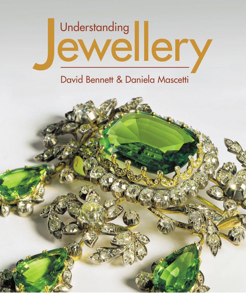 Off white cover with a colour photograph of a piece of jewellery made from diamond and peridot green jewels with Understanding Jewellery David Bennett and Daniela Mascetti orange and gold font, by ACC Art Books