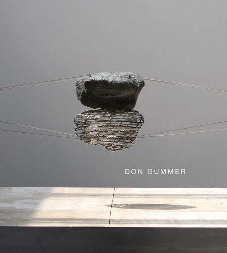2 rock like sculpture pieces held together in air by steel cables with shadows reflected on surface below with Don Gummer in white font