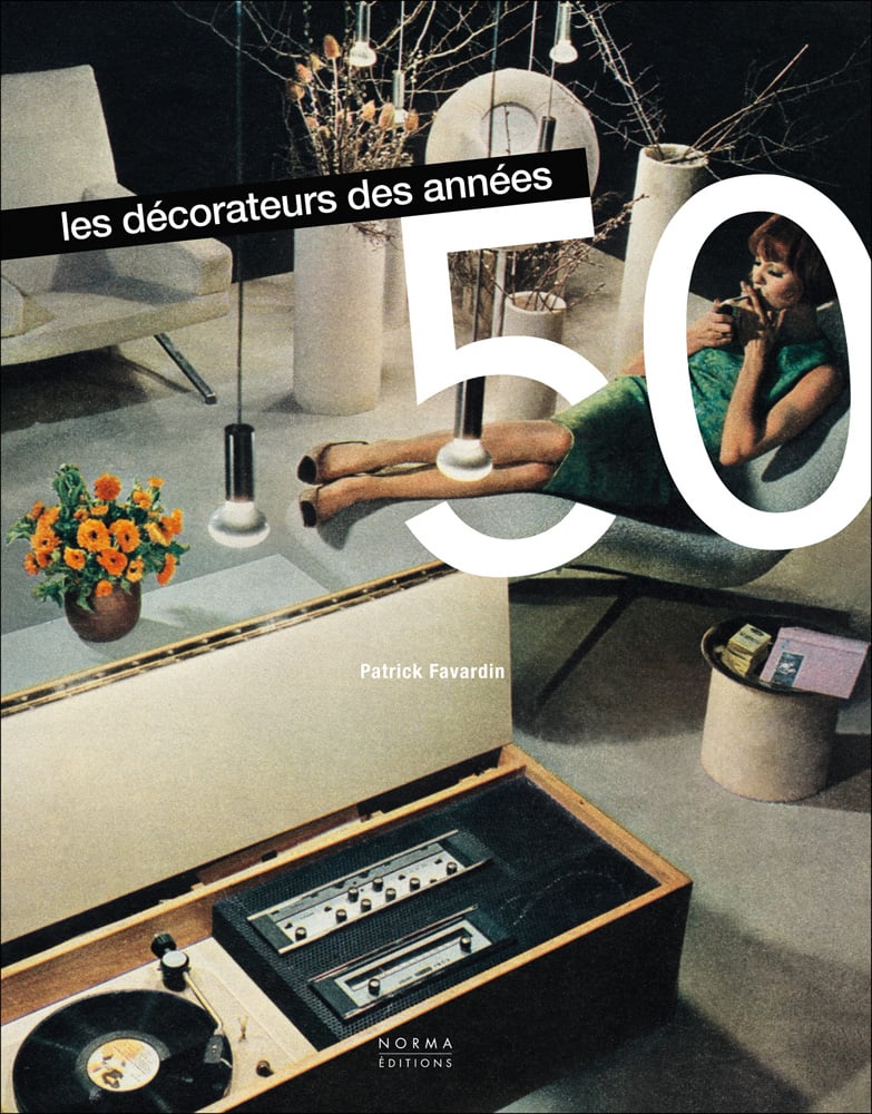 Women wearing green dress sitting back in chair while lighting a cigarette, record player to left, on cover of 'Décorateurs des années 50', by Editions Norma.