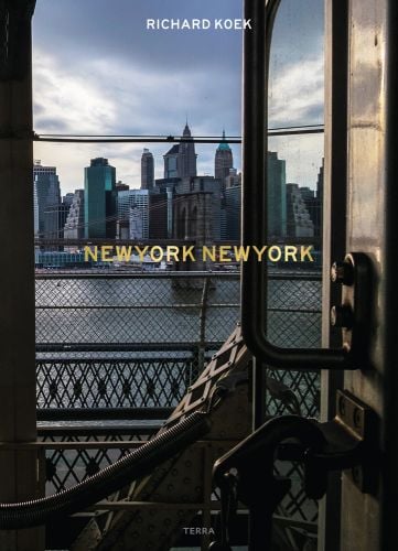 View of New York skyline and Hudson river from train door with New York New York in gold font in centre