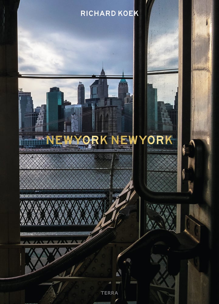 View of New York skyline and Hudson river from train door, on cover of 'New York New York', by Lannoo Publishers.