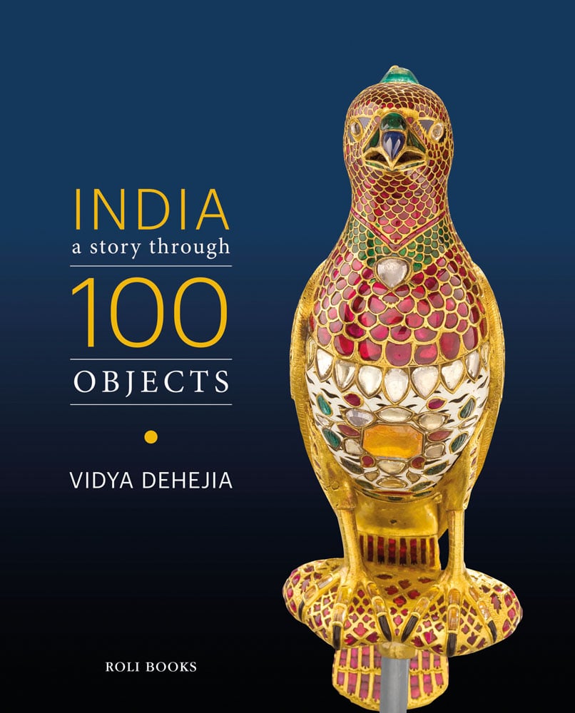 Decoratively painted ceramic figure of bird in gold and red on dark blue cover with India: A Story Through 100 Objects in yellow and white font