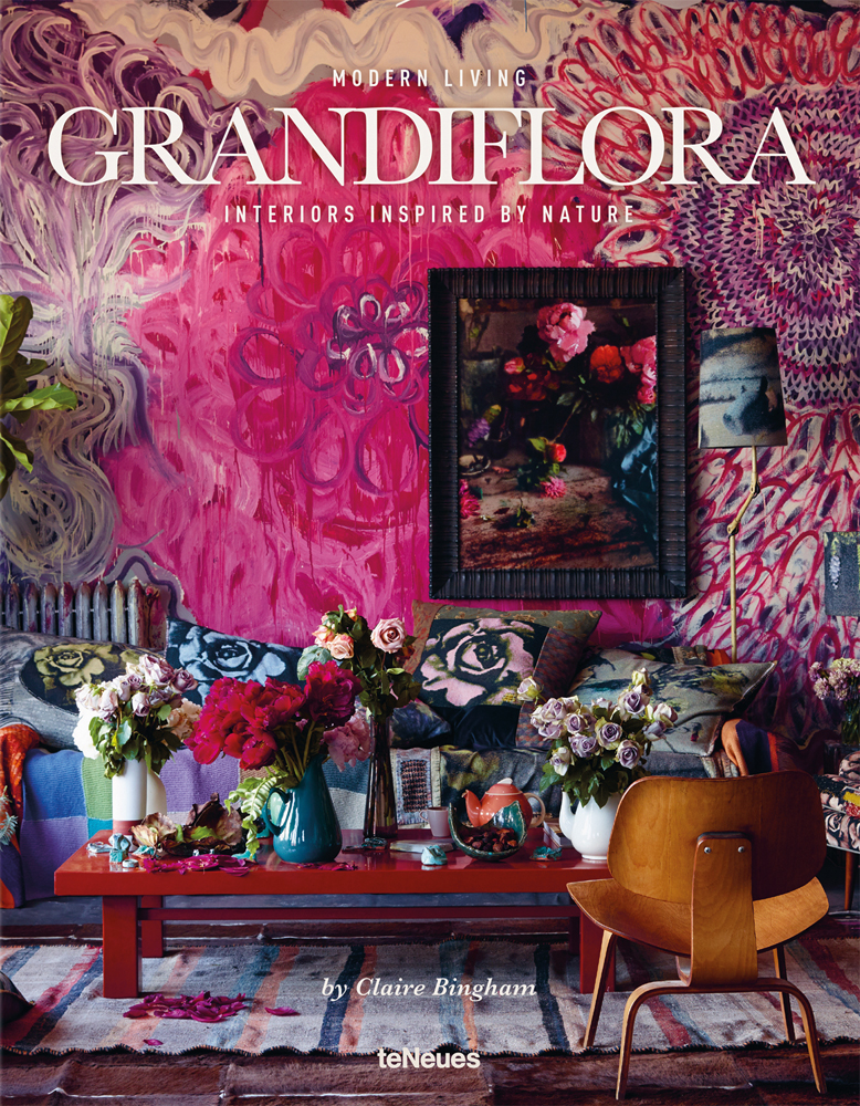 Bright, bold interior space, with floral wallpaper and cushions, 'MODERN LIVING GRANDIFLORA, in white font above.