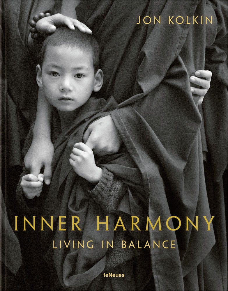 Child Buddhist in robes clutching hands of obscured figure with Inner Harmony Living in Balance in gold font