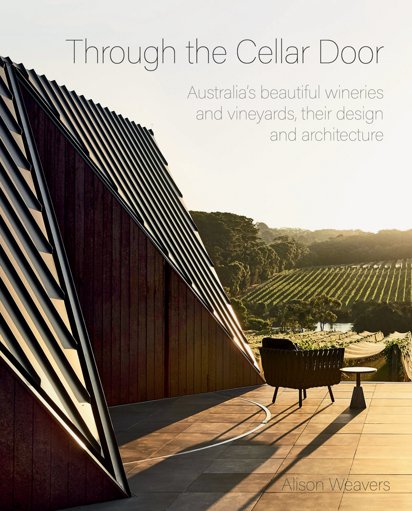 Outdoor view of modern architectural winery with vineyards in the distance and Through the Cellar Door in fine black font above