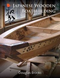 Book cover of Japanese Wooden Boatbuilding, with a carved wood boat in workshop. Published by Floating World Editions.