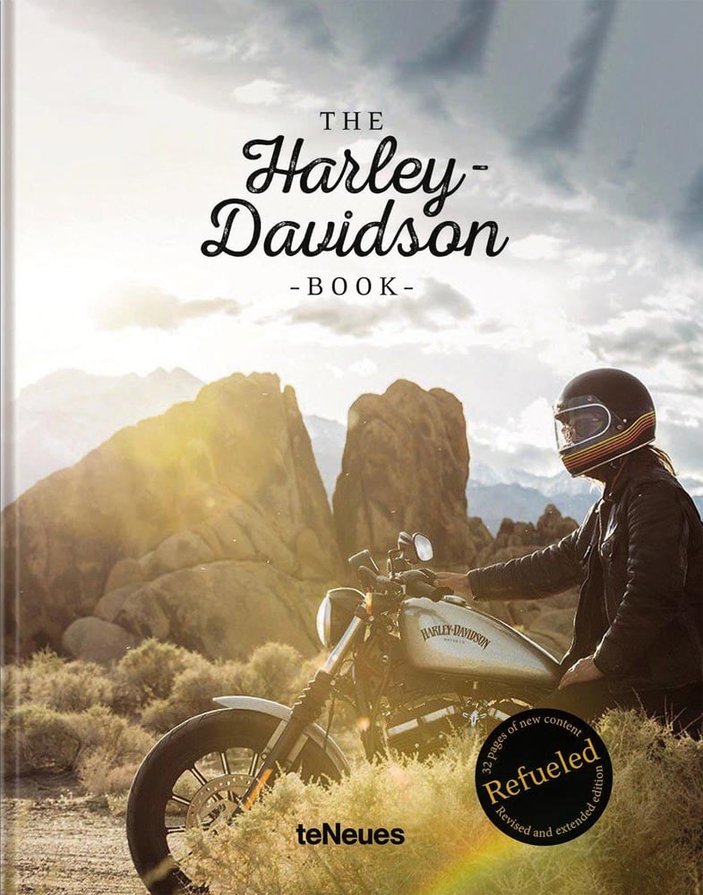 Book cover of The Harley-Davidson Book - Refueled, featuring a biker on Harley Davidson, riding through desert landscape with rocky mountains behind. Published by teNeues Books.