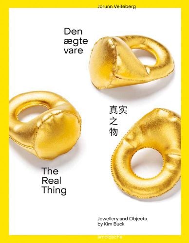 Three gold rings made from shiny fabric with stuffing, on white cover of 'The Real Thing Jewellery and Objects by Kim Buck', by Arnoldsche Art Publishers.