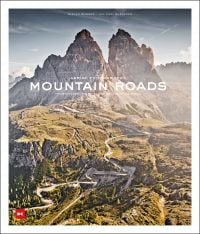Mountainous landscape with green terrain with winding roads, on cover of 'Mountain Roads, Aerial Photography. Traumstraßen der Welt / Dreamroads of the world', by Delius Klasing Verlag GmbH.