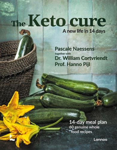 Pile of green courgettes with yellow flowers cut off on worktop, basket to left, on cover of 'The Keto Cure, A New Life in 14 Days', by Lannoo Publishers.