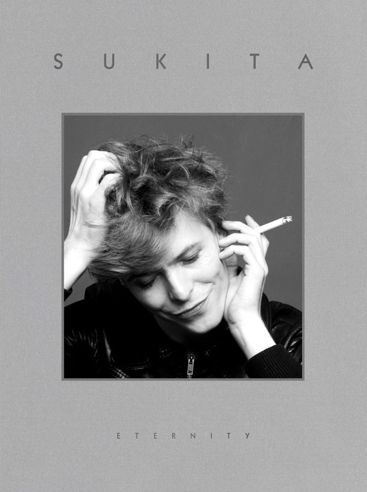 Photograph of David Bowie, holding cigarette, 'Just for One Day', 1973, on grey cover of 'Sukita, Eternity', by ACC Art Books.