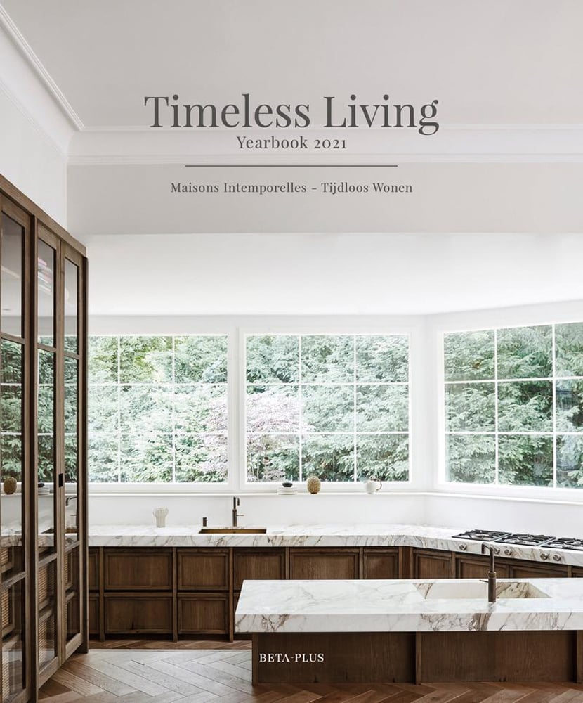 Pale interior with marble topped units, windows looking out to green hedge with Timeless Living Yearbook 2021 in grey font above
