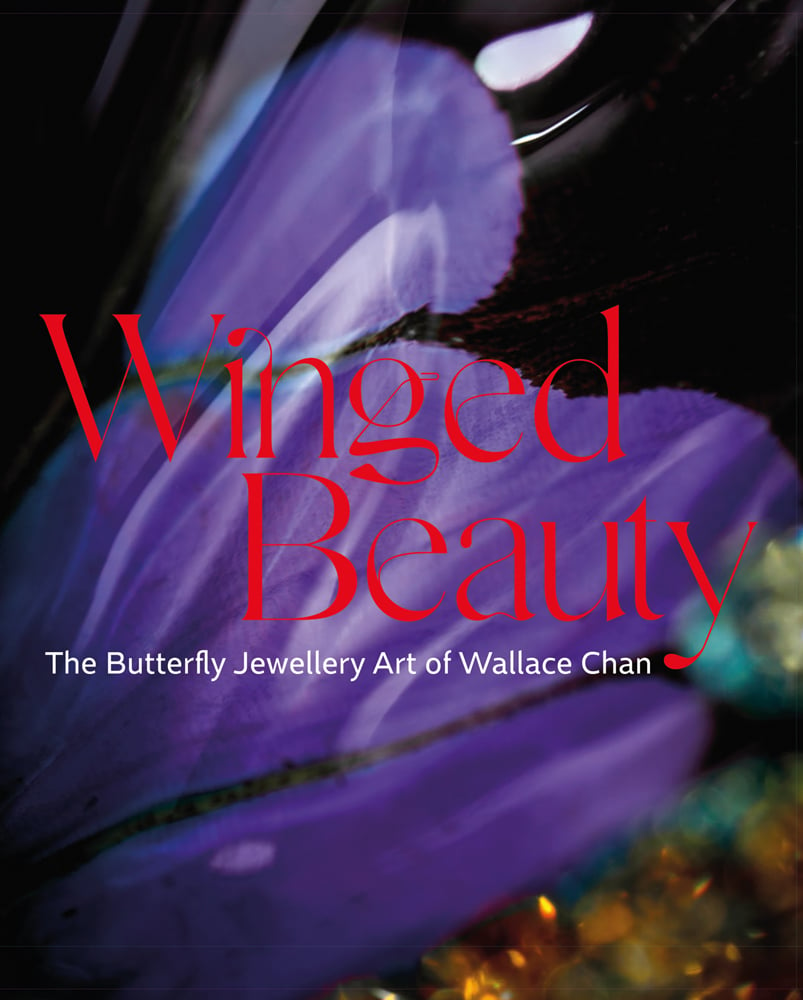 Close up colour photograph of a purple wing shaped image above some blurred blue and yellow gemstones and Winged Beauty The Butterfly Jewellery Art of Wallace Chan in red and white