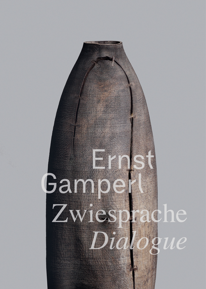 Carved wood vessel with curved split joined together, on grey cover of 'Ernst Gamperl, Dialogue', by Arnoldsche Art Publishers.