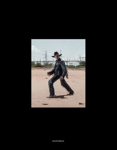 Black tasselled leather clad cowboy posing on sandy ground, on black cover of 'Hellbangers', by Hannibal Books.