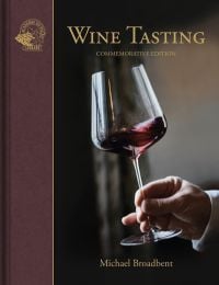 Hand gently swirls a glass of red wine, on cover of 'Wine Tasting', by Academie du Vin Library.