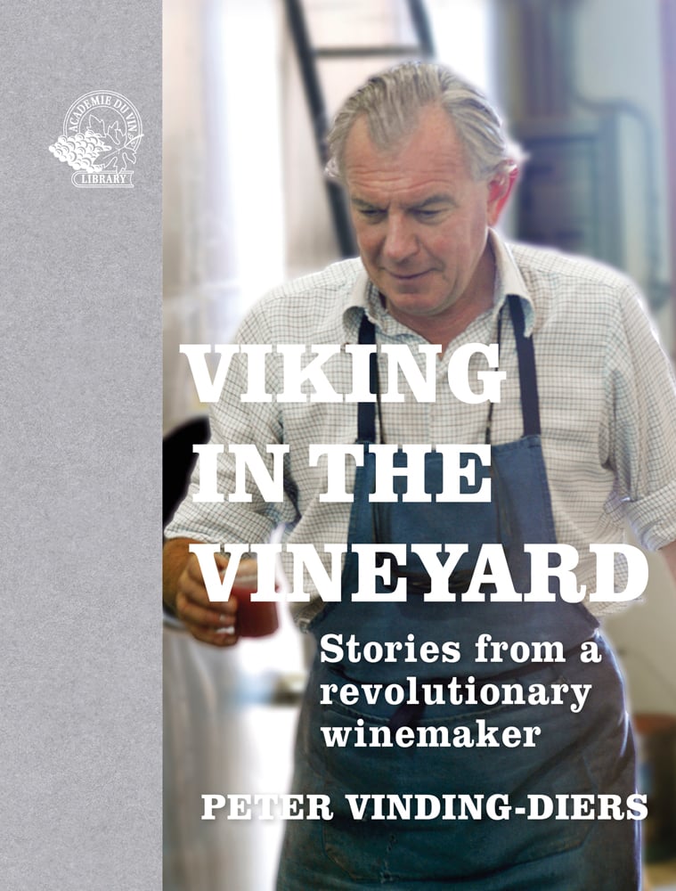 Peter Vinding-Diers in blue apron and checked shirt holding clear cup with red liquid and Viking in the Vineyard in white font