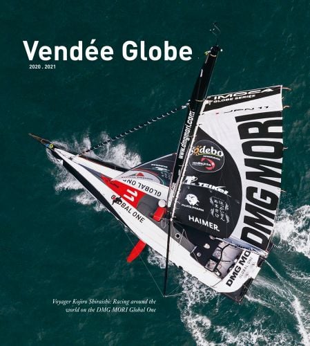 Dramatic birds eye view of DMG MORI Global One racing boat sailing through ocean, on cover of 'Vendée Globe 2020.2021, Voyager Kojiro Shiraishi: Racing around the world on the DMG MORI Global One', by Delius Klasing Verlag GmbH.