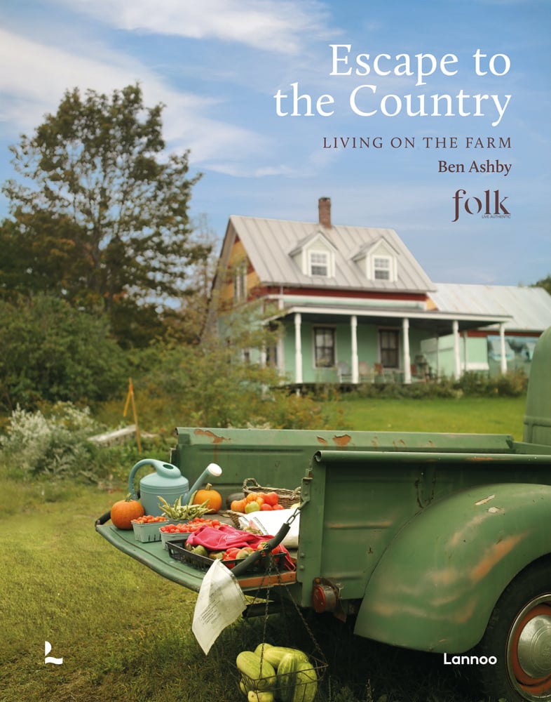 Old American farm truck, fresh fruit and vegetables on a tray with watering can resting on back door, on cover of 'Escape to the Country', by Lannoo Publishers.