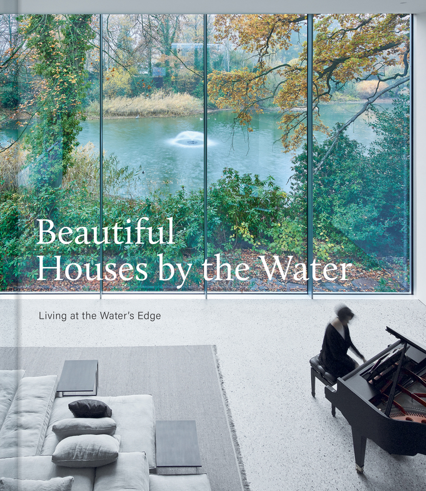 Pianist playing piano in living room interior with large windows, overlooking pond with fountain, Beautiful Houses by the Water, in white font to left of centre.
