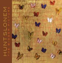 Gold textured cover with small paintings of butterflies and Hunt Slonem in yellow font on brown left banner