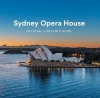 Landscape photo of Sydney Opera House surrounded by blue water, under evening sky, Sydney Opera House OFFICIAL SOUVENIR GUIDE in white font above.