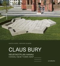 Geometric granite sculpture of map embedded in green grass, on cover of 'Claus Bury, Hanau New Town Map', by Arnoldsche Art Publishers.