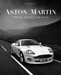 Book cover of Aston Martin: Power, Beauty and Soul, featuring a white Aston Martin V12 Vanquish on the road, with mountains behind. Published by Images Publishing.