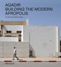 Man walking past white buildings in Moroccan city of Agadir, under blue sky, AGADIR BUILDING THE MODERN AFROPOLIS in black font above.