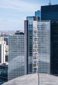 Colour photo of 32-storey high-rise Trinity tower with glass exterior shining in sunlight and Cro&Co in small white font below