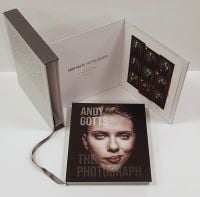 Scarlett Johansson smirking at camera, on black cover of 'Andy Gotts The Photograph; Ringo Starr Deluxe Edition', by ACC Art Books.
