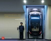 Book cover of Porsche Panamera, From Idea to Perfection, featuring a Porsche Panamera parked on vertical ramp, with man in blue uniform on guard to left. Published by Delius Klasing.