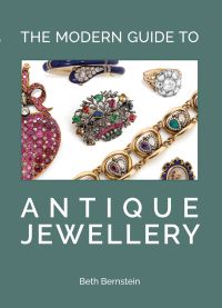 Collection of antique jewellery pieces on sage cover of 'The Modern Guide to Antique Jewellery, Beth Bernstein', by ACC Art Books.