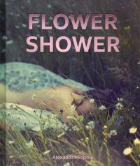 Low angle of daisies in prairie landscape, blurred image of nude female laying on front, FLOWER SHOWER Alexandra Sophie in pink metallic font