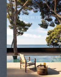 Book cover of Living by the Sea, with a table and chair near swimming pool, with sea view behind. Published by Beta-Plus.