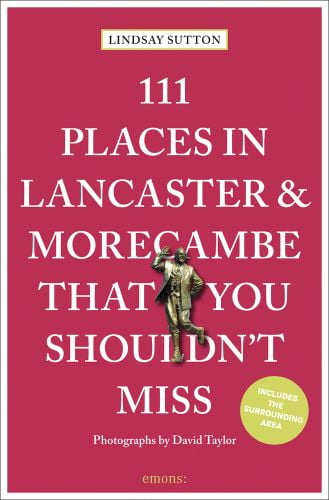 Bronze statue of Eric Morecambe near center of red cover of '111 Places in Lancaster and Morecambe That You Shouldn't Miss', by Emons Verlag.