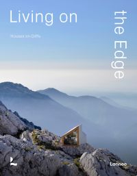 Modern home with glass side, built on cliff edge with mountains behind, under blue sky, on cover of 'Living on the Edge', by Lannoo Publishers.