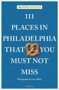 Pretzel near centre of blue cover of '111 Places in Philadelphia That You Must Not Miss', by Emons Verlag.