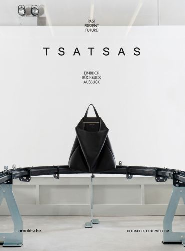 Large black leather bag on metal structure, white cover, PAST PRESENT FUTURE TSATSAS in black font above