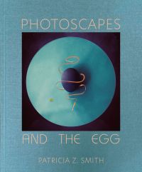 Aerial image of dark blue egg on blue circle, PHOTOSCAPES AND THE EGG, in beige font to top and bottom of blue cover.