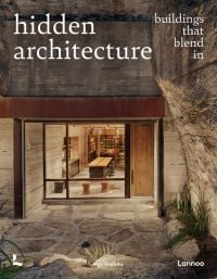 Illuminated interior living space, surrounded by carved rock, on cover of 'Hidden Architecture, Buildings that Blend In', by Lannoo Publishers