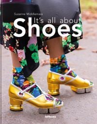 Book cover of It’s All About Shoes, featuring the feet of fashion model wearing Gucci, gold patent leather sandals, with colourful socks. Published by teNeues Books.