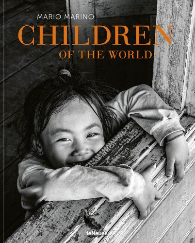 Small child smiling up at camera, arms and hands clutching window ledge, Children of the World in orange font above, by teNeues Books.