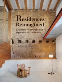 Interior room with exposed brickwork, beamed ceiling, armchair on white tiled floor, Residences Reimagined, in brown font above.