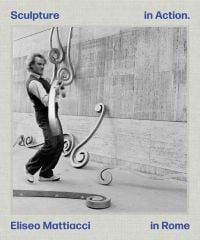 Italian sculptor Eliseo Mattiacci assembling large installation sculpture on wall, on grey cover, Sculpture in Action Eliseo Mattiacci in Rome in blue font to top and bottom edges.