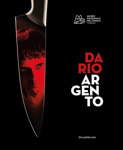 Dario Argento reflected in sharp knife, with red filter, black cover, DARIO ARGENTO in red and white font to lower right side.
