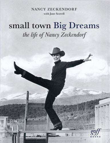 Nancy King Zeckendorf performing a high kick, mountain landscape behind, small town Big Dreams, in dark font above.