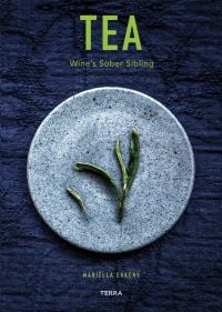 Book cover of Tea', Wine's Sober Sibling, with green tea leaves on blue plate. Published by Lannoo Publishers.